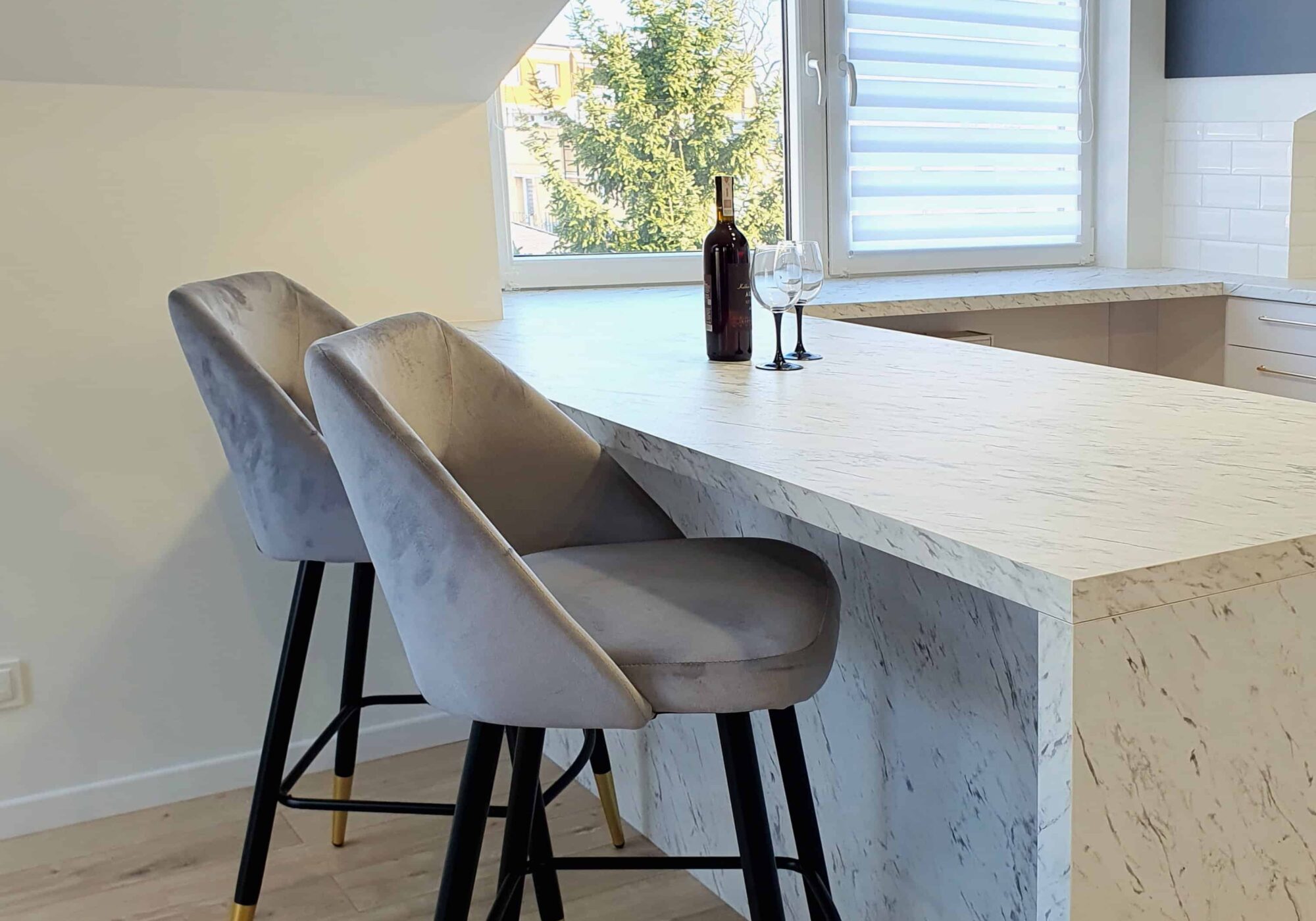 Czarno-złota lampa wisząca nad wyspą kuchenną, wyrafinowany design i staranne wykończenia.